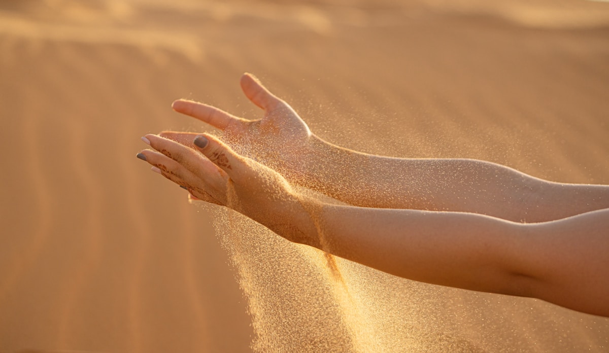 Photo by Hassan OUAJBIR persons feet on brown sand