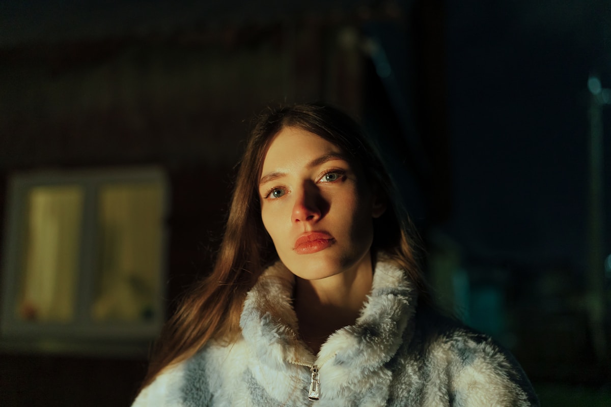 A woman in a fur coat standing in front of a building